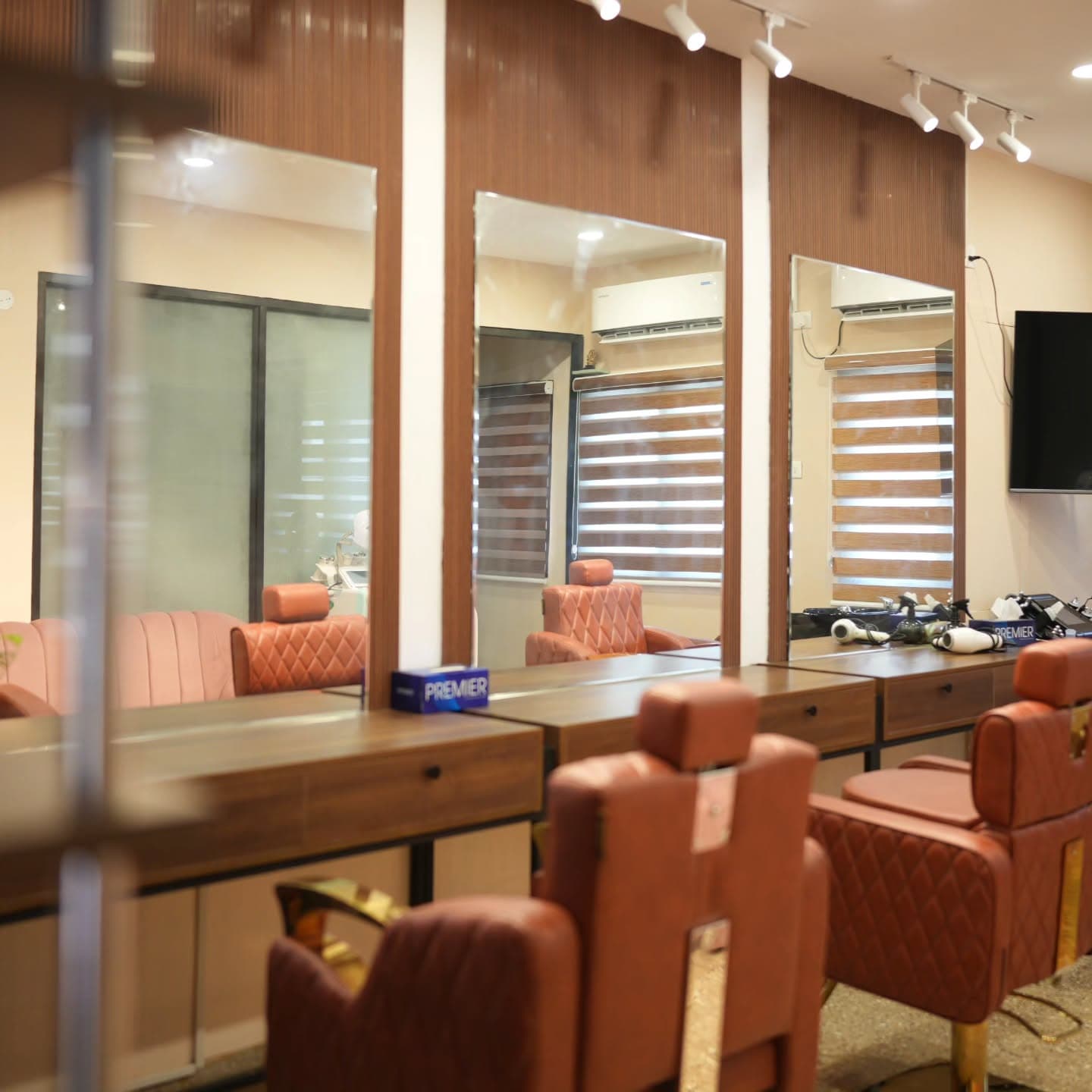 Styling stations with fluted wood paneling and cognac chairs